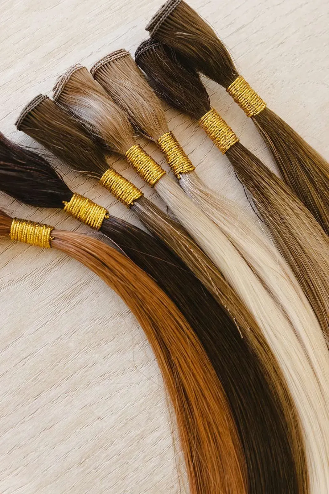 A bunch of different colored hair extensions are sitting on a table.