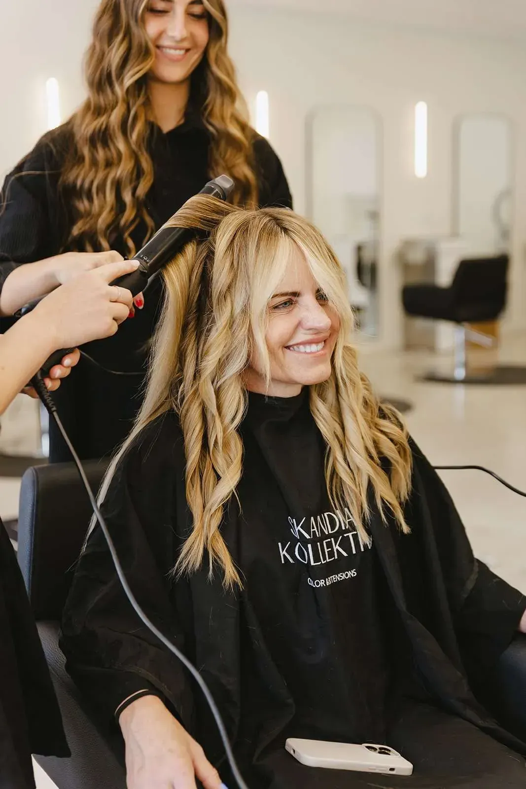 A woman is getting her hair blow dried in a salon.